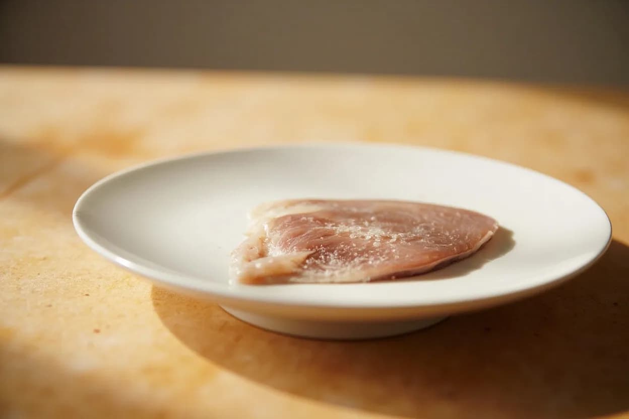 Butterfly Fillet (Herring / Sardine Method) in its raw whole-cut form on a butcher's board — The butterfly fillet technique for small round fish (herring, sardine, mackerel, sprat, anchovies) involves splitting the fish along its ventral (belly) surface, then pressing the two fillets flat wh… Identifying traits: Flat, open configuration exposes maximum surface area for marinades and cures, Both fillets remain skin-on, helping hold the butterfly together during cooking, Backbone removed whole — makes eating easier and allows rolling (rollmops).