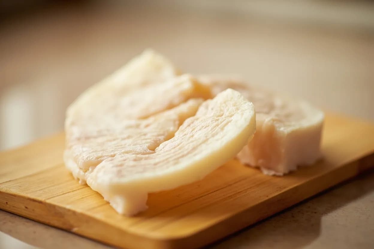 Scallop Preparation (Vieiras) in its raw whole-cut form on a butcher's board — Scallop preparation covers the full technique of opening a live scallop shell, separating the round white adductor muscle (the part most commonly eaten in commerce), removing the grey-brown gills and… Identifying traits: Naturally sweet, oceanic flavor with a clean, mild brine, Adductor muscle is dense, round, and pearlescent white to pale ivory, Roe (when present) is creamy orange-red and has a more intense, livery-briny flavor.