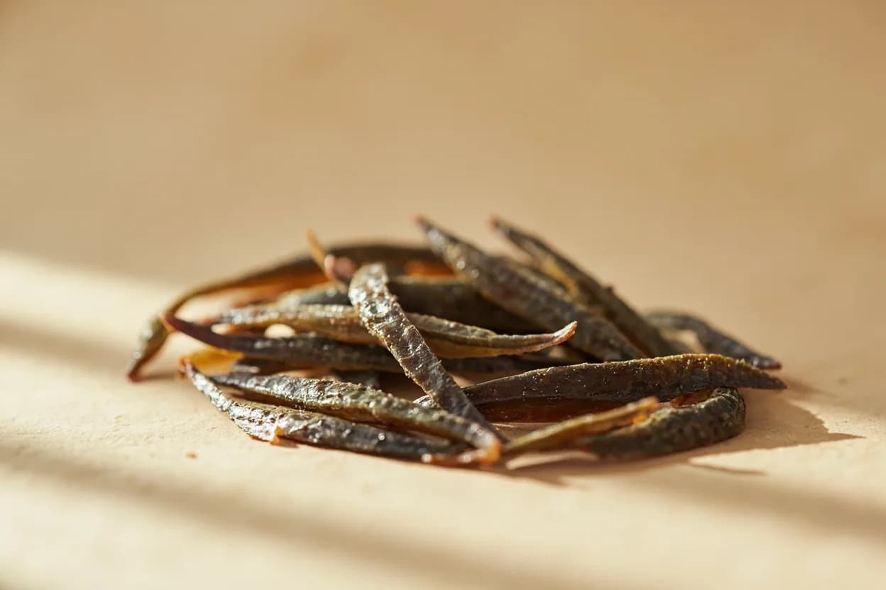 Anchovy (as flavoring) in its natural form. Anchovy used as a flavouring agent — dissolved into hot fat, mashed into sauces, whisked into dressings — functions as one of the world's most powerful umami boosters. Tasting profile: intense free glutamates (umami depth), salt-forward brine, fermented complexity (lactic, funky), meaty richness when dissolved in fat.