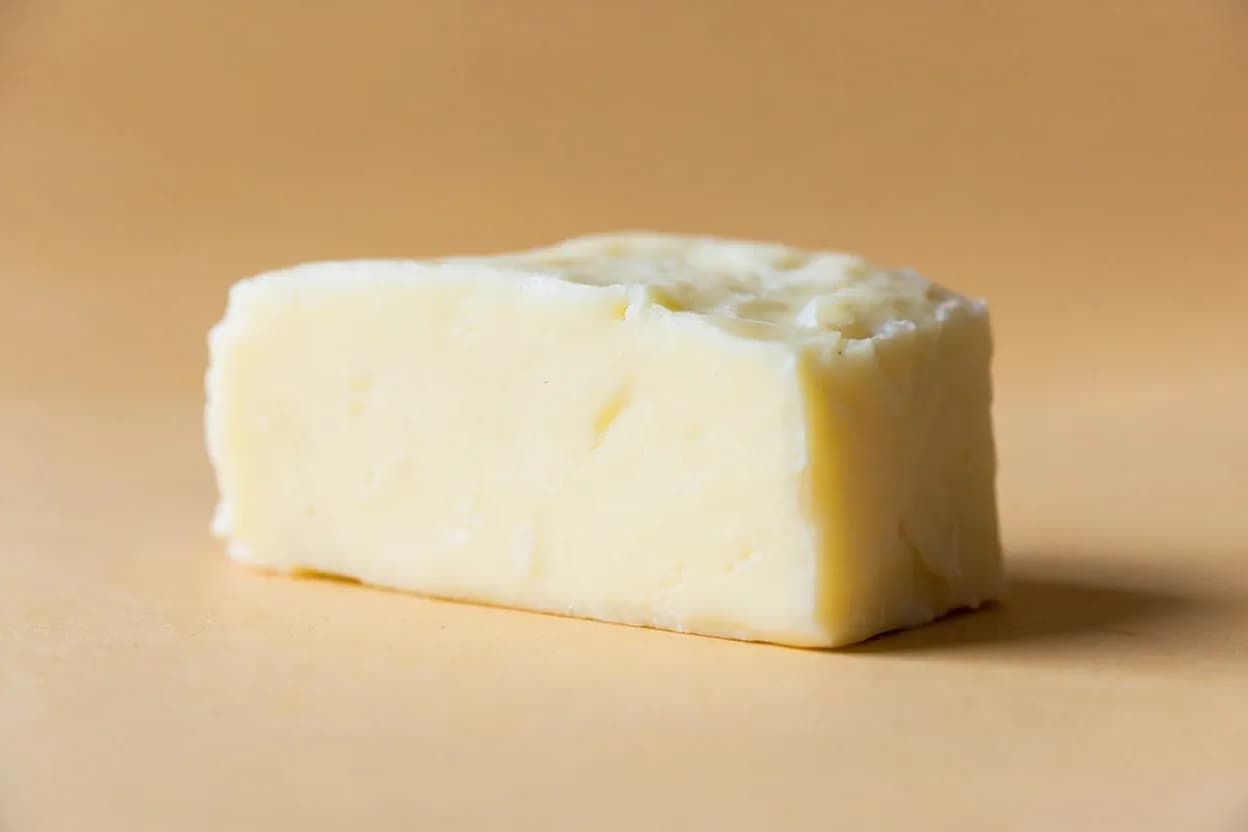 Ayib (Ethiopian Fresh Cheese) in its natural form. Ayib is Ethiopia's indigenous fresh cheese, made by heating soured buttermilk or whey until the curds separate, then draining them through cheesecloth. Tasting profile: clean fresh milk, gentle lactic acid / sour cream edge, mild salt, light fermented tang from buttermilk base.