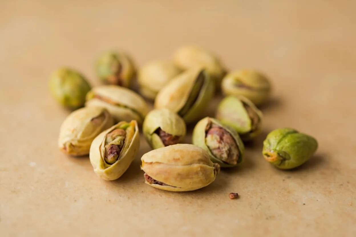 Pistachio in its natural form. The pistachio (Pistacia vera) is a drupe native to Central Asia and the Middle East, prized for its split green kernel and its flavor — a distinctive combination of buttery sweetness, mild nuttiness,… Tasting profile: Buttery, creamy nuttiness, Sweet, mild almond-adjacent note, Green, grassy, herbal freshness (raw), Roasted pyrazines (toasted, nutty) when roasted.