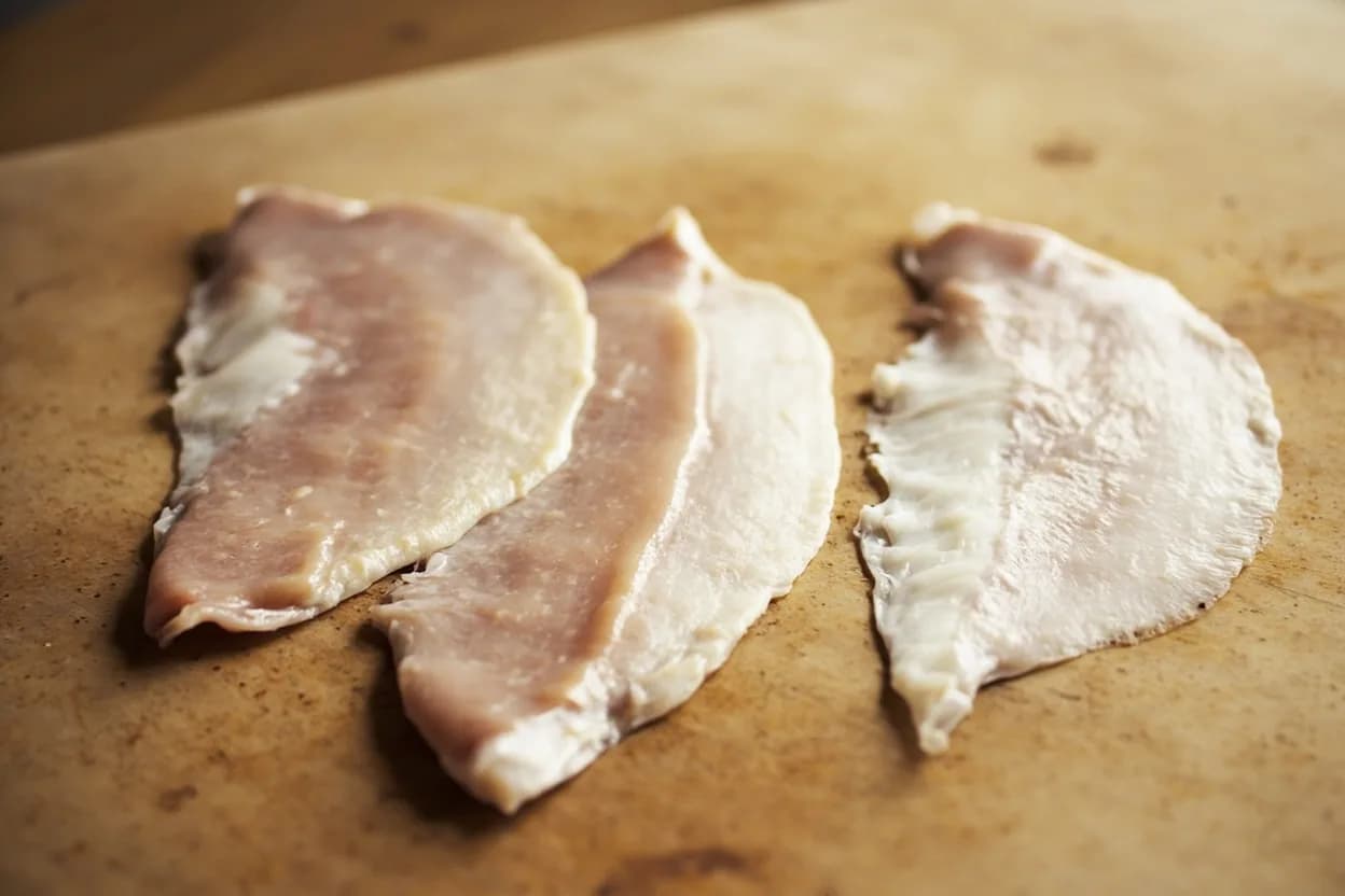 Flat Fish Filleting — Four-Fillet Method (Sole & Flounder) in its raw whole-cut form on a butcher's board — Unlike round fish, flatfish (sole, flounder, plaice, turbot) lie and swim on one side, with both eyes migrated to the upper surface. Identifying traits: Thin, flat, and almost translucent when raw — delicate handling required, Fine, clean flavor with minimal fishiness, especially Dover sole, The dark-side (upper/blind-side) fillets are nominally larger; white-side fillets slightly smaller.