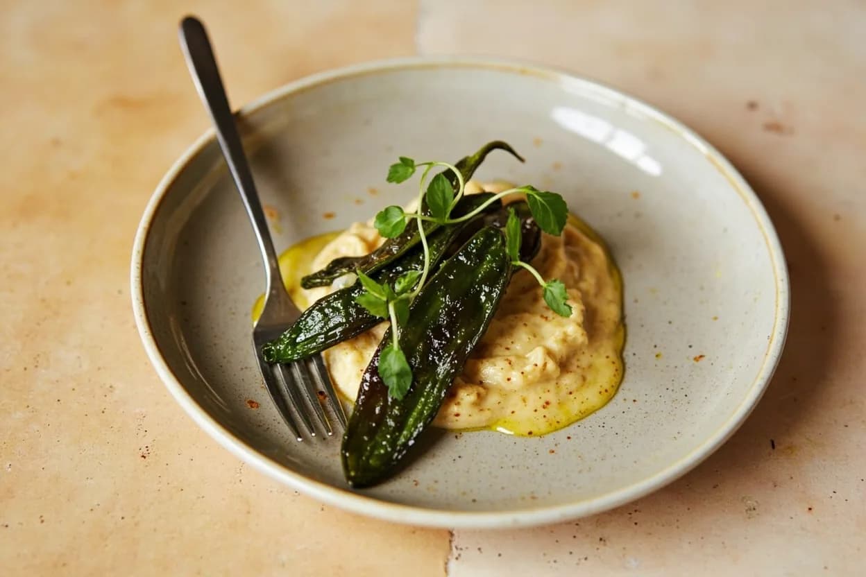 Rajas (Roasted Chile Strips) prepared the canonical way — Rajas con crema (Mexico City classic). Char the whole chile directly over a gas burner on high, turning with tongs every 30–45 seconds, until the skin is blackened on all sides — roughly 4–6 minutes total. Alternatively, broil 10 cm from the element, turning once.