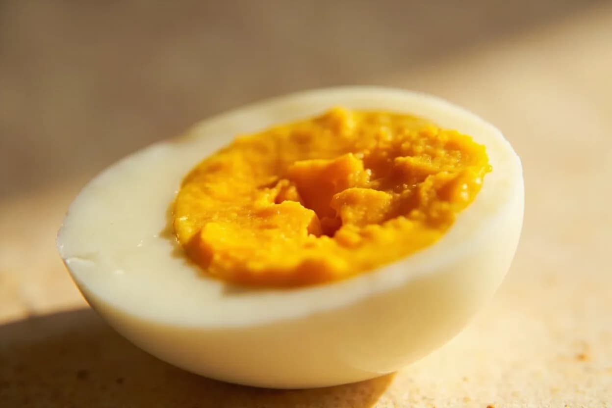 Hard-Boiled Egg: Fully Set at 77°C / 170°F. Above 77°C, the remaining yolk lipoproteins and phosvitin fully denature, forming a solid, self-supporting gel. Visual cues: Yolk is uniformly pale, opaque yellow with no translucency or wet sheen, Yolk holds its dome shape when halved and does not smear or flow, No grey-green ring at the yolk–white interface in a properly cooked egg.