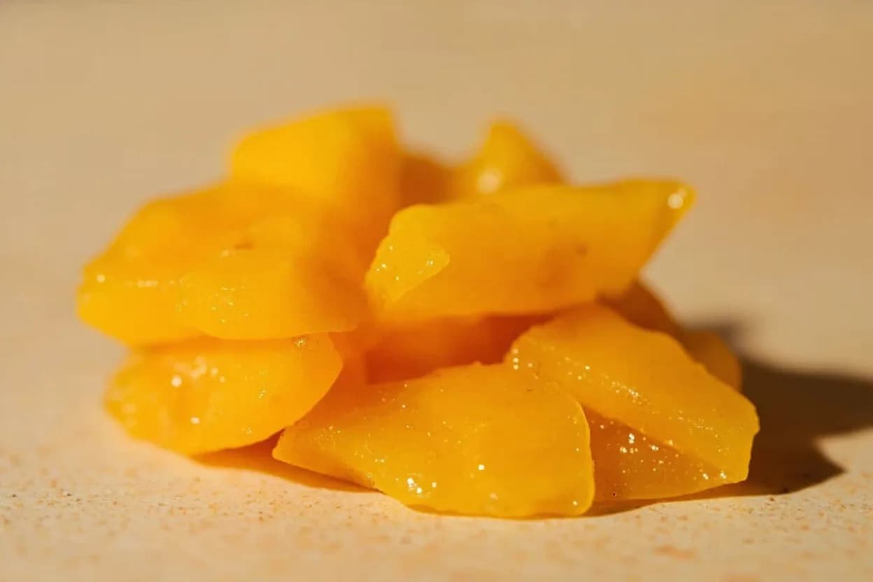 Amba (Pickled Mango) in its natural form. Amba is a pungent, golden-orange mango pickle originating in Iraq, brought to Israel in the 1950s by Iraqi Jewish immigrants and now inseparable from Israeli street food culture. Tasting profile: sharp fermented mango tartness, fenugreek bitterness (maple-adjacent, slightly musky), turmeric earthiness, dried chili heat.