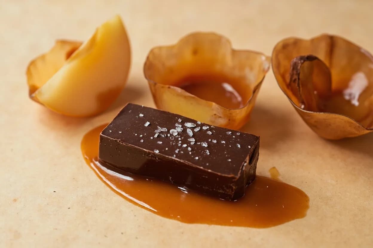 Caramel paired with Dark chocolate (French, British) — the canonical affinity made visible. Caramel's Maillard sweetness and chocolate's cacao bitterness are complementary: one is the bittersweet inversion of the other, creating the core of praline, chocolate caramel tart, and millionaire's shortbread.